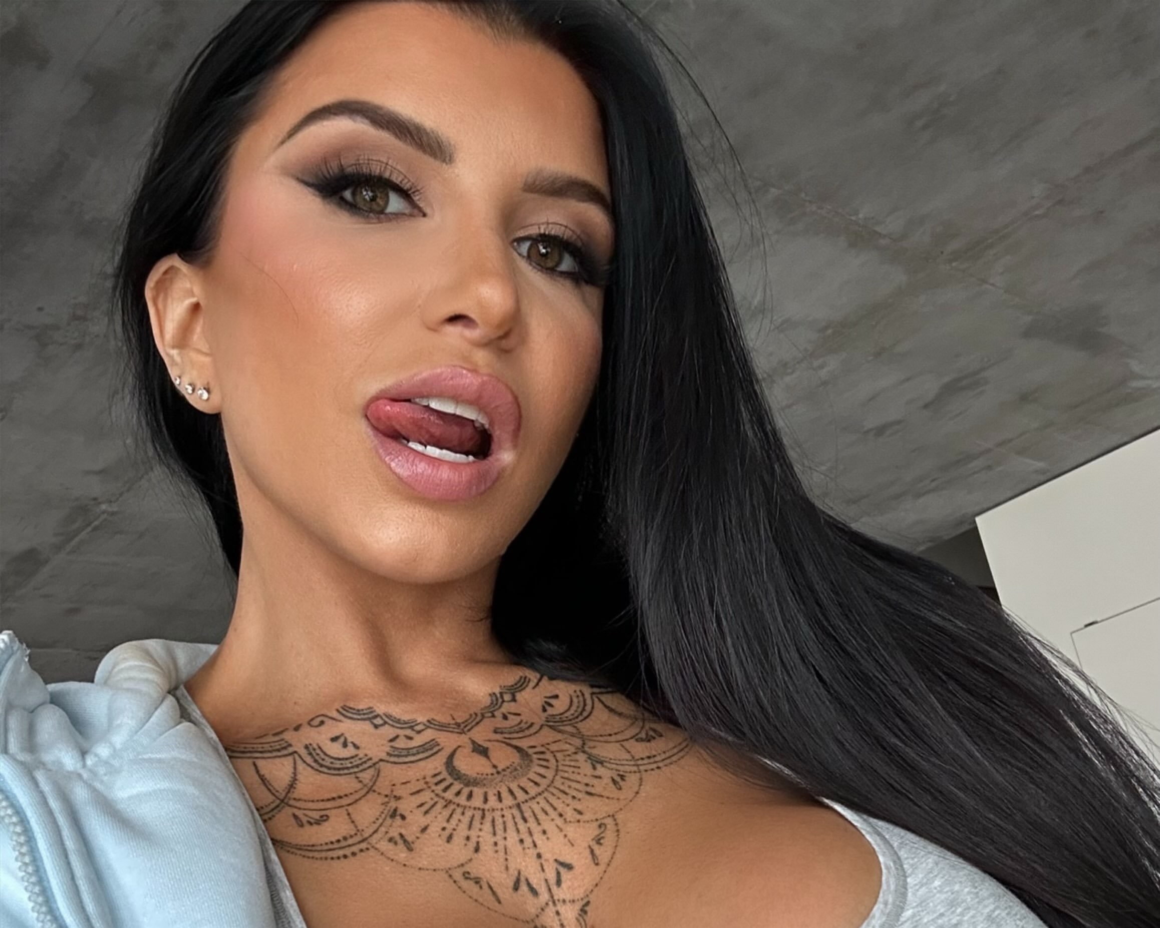 Romi Rain wearing a blue hoodie